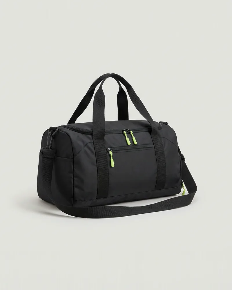 Black gym duffel bag with lime zip pulls on a pale grey background